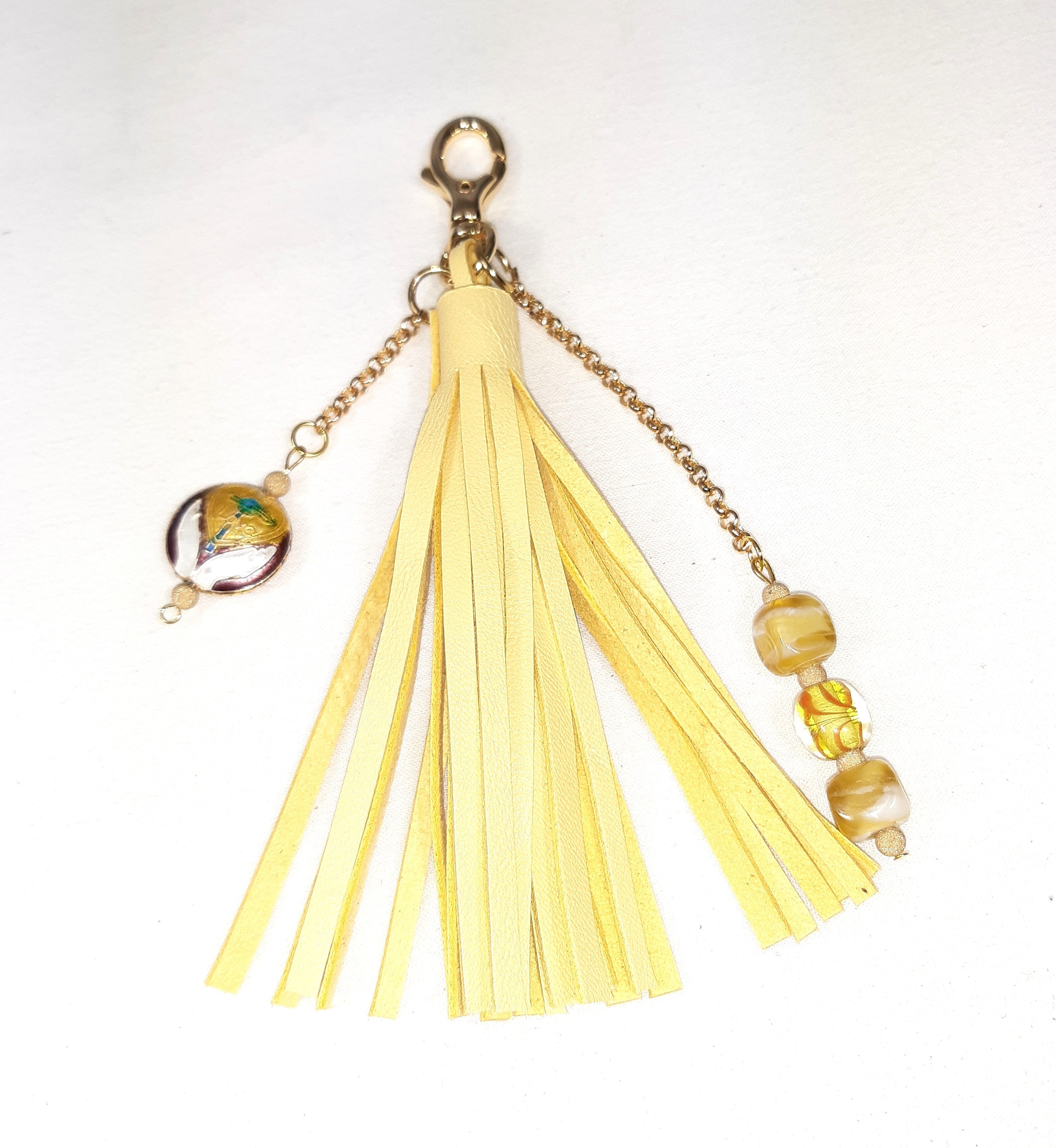 Bijou de sac, pompon cuir coloris jaune avec perles en verre filé et cloisonné.